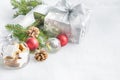 Christmas gift box in silver wrapping paper over a white fluffy background. A jar full of star cookies and christmas decoration.