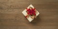 Christmas gift box tied with red and golden bow over a wooden table Royalty Free Stock Photo