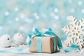 Christmas gift box and white jingle bell against blue bokeh background. Holiday greeting card. Royalty Free Stock Photo