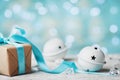 Christmas gift box and white jingle bell against turquoise bokeh background. Holiday greeting card. Royalty Free Stock Photo