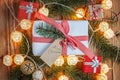 Christmas gift box on wooden background with Fir branches, jingle bell, small presents and Christmas light. Xmas and Happy New Yea Royalty Free Stock Photo