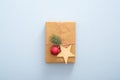 Christmas gift box with wooden star, red ball, fir tree branches on pastel blue background. Christmas, New Year, winter holiday Royalty Free Stock Photo