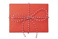 Christmas gift box wrapped in red paper with striped rope bow isolated on white background Royalty Free Stock Photo