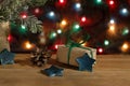 Christmas gift box in wrapping paper, stars and pinecone on background