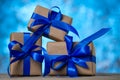 Christmas gift boxes with blue ribbons against blue lights garland and bokeh background. Holiday greeting card