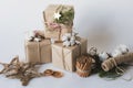 Christmas gift boxes with flowers and decorative objects Eco cotton, cinnamon, spruce branches and jute rope hank over white backg