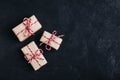 Christmas gift boxes with red ribbon decor on dark stone background. Top view Royalty Free Stock Photo