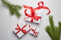 Christmas gift boxes with red ribbon and green pine tree branch with cones on white Royalty Free Stock Photo