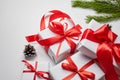 Christmas gift boxes with red ribbon and green pine tree branch with cones on white Royalty Free Stock Photo