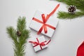 Christmas gift boxes with red ribbon and green pine tree branch with cones on white Royalty Free Stock Photo