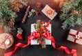 Christmas gift boxes with red ribbon on holiday background with pencil, Fir branches, pine cones. Xmas Royalty Free Stock Photo