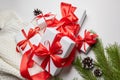 Christmas gift boxes with red ribbon and knitted sweater with green pine tree branch and cones on white Royalty Free Stock Photo