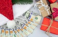 Christmas gift boxes and red Santa hat with american one hundred dollar bills Royalty Free Stock Photo