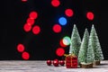 Christmas gift boxes under pine tree on wooden table over bokeh background Royalty Free Stock Photo