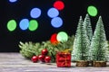 Christmas gift boxes under pine tree on wooden table over bokeh background Royalty Free Stock Photo