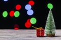 Christmas gift boxes under pine tree on wooden table over bokeh background Royalty Free Stock Photo