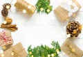 Christmas gift boxes wrapped in brown Kraft paper tied with twine pine cones cypress cinnamon nuts in sparkling lights on white Royalty Free Stock Photo