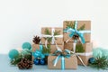 Christmas gift boxes wrapped of craft paper, blue and white ribbons and Christmas lights on the blue and white background. Royalty Free Stock Photo