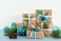 Christmas gift boxes wrapped of craft paper, blue and white ribbons and Christmas lights on the blue and white background. Royalty Free Stock Photo