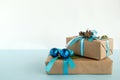 Christmas gift boxes wrapped of craft paper, blue and white ribbons, decorated of fir branches and Christmas balls. Royalty Free Stock Photo