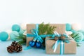 Christmas gift boxes wrapped of craft paper, blue and white ribbons, decorated of fir branches, pine cones and Christmas balls. Royalty Free Stock Photo