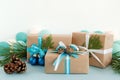 Christmas gift boxes wrapped of craft paper, blue and white ribbons, decorated of fir branches, pine cones and Christmas balls. Royalty Free Stock Photo