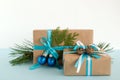 Christmas gift boxes wrapped of craft paper, blue and white ribbons, decorated of fir branches, pine cones and Christmas balls. Royalty Free Stock Photo