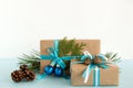 Christmas gift boxes wrapped of craft paper, blue and white ribbons, decorated of fir branches, pine cones and Christmas balls. Royalty Free Stock Photo