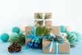 Christmas gift boxes wrapped of craft paper, blue and white ribbons and Christmas lights on the blue and white background. Royalty Free Stock Photo