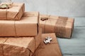 Christmas gift boxes wrapped in kraft paper on blue wooden table. Zero waste, eco friendly packaging Royalty Free Stock Photo