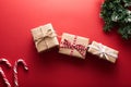 Christmas gift boxes wrapped kraft paper decorated ribbon bow and fir branches on marsala red background. Flat lay, top Royalty Free Stock Photo