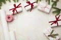 Christmas gift boxes wrapped in white craft paper and decorative red ribbon on marmoreal surface. Flat lay, top view.