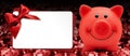 christmas gift card with red bow and piggy bank on blurred bright lights, template copy space