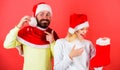 Christmas gift concept. Woman and bearded man in santa hat expecting gift red background. Check contents of christmas Royalty Free Stock Photo