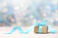 Christmas gift,craft box with blue ribbon on wooden white table blurred lights background empty space.New year backdrop Royalty Free Stock Photo