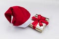 A Christmas gift in a festive package and a Santa Claus hat lies on the snow Royalty Free Stock Photo