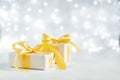 Christmas gift with a gold bow on a sparkling bokeh background. Copy space for text Royalty Free Stock Photo