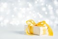 Christmas gift with a gold bow on a sparkling bokeh background. Copy space for text Royalty Free Stock Photo