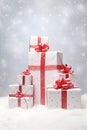 Christmas gift group with red ribbons on snow covered surface.