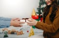 Christmas Gift in hands. Happy Man giving Christmas and New Year Gift box to woman at Home. Family Xmas celebration. Christmas Royalty Free Stock Photo