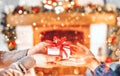 Christmas Gift in hands. Happy Man giving Christmas and New Year Gift box to woman at Home. Family Xmas celebration Royalty Free Stock Photo