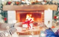 Christmas Gift in hands. Happy Man giving Christmas and New Year Gift box to woman at Home. Family Xmas celebration Royalty Free Stock Photo