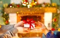 Christmas Gift in hands. Happy Man giving Christmas and New Year Gift box to woman at Home. Family Xmas celebration Royalty Free Stock Photo