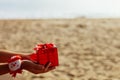 Christmas gift in red box on the beach Royalty Free Stock Photo