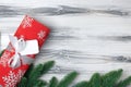 Christmas gift in red packaging and with a white bow on a wooden white background Royalty Free Stock Photo