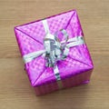 Christmas gift with ribbon wrapped in a shiny purple paper Royalty Free Stock Photo