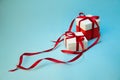 Christmas Gift`s in White Box with Red Ribbon on Light Blue Background. New Year Holiday Composition. Copy Space For Your Text Royalty Free Stock Photo