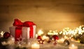 Christmas gift with snow, candles and ornaments Royalty Free Stock Photo