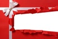 Christmas gift torn open strip, white ribbon bow, red wrapping paper Royalty Free Stock Photo