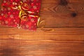 Christmas gift, trendy red present box wrapped with golden ribbon decoration on rustic wooden background. Flatlay style Royalty Free Stock Photo